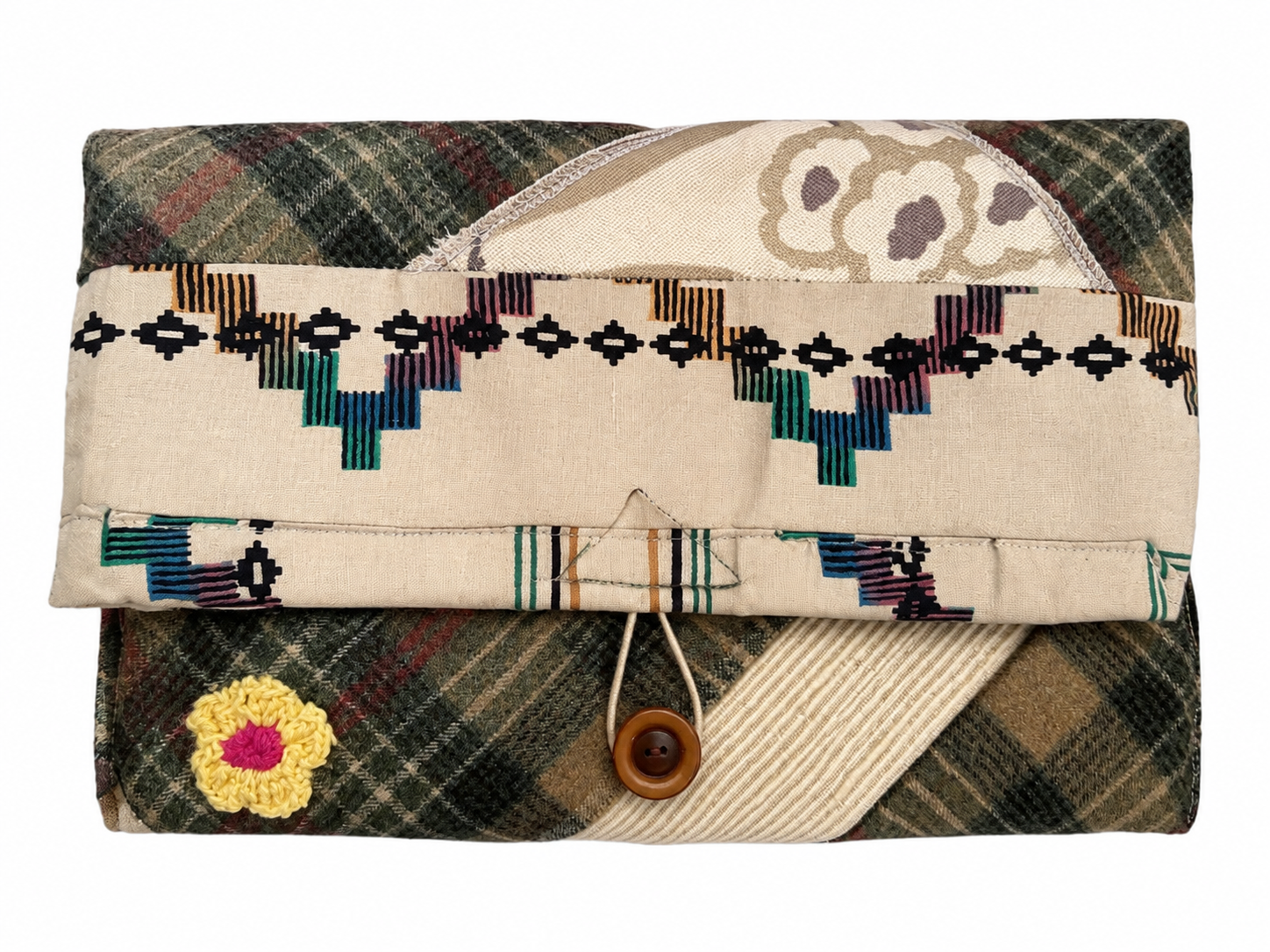Opvouwbare clutch van bedrukte stof met beige klep, veelkleurig borduurwerk en een sluiting met houten knoop.
