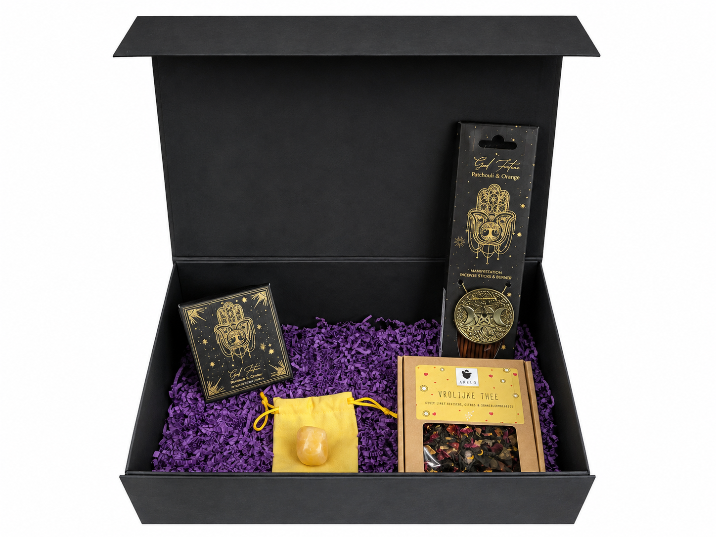 Zwarte geschenkdoos met zwart-gouden verpakte artikelen op paars snipperpapier als opvulling.
