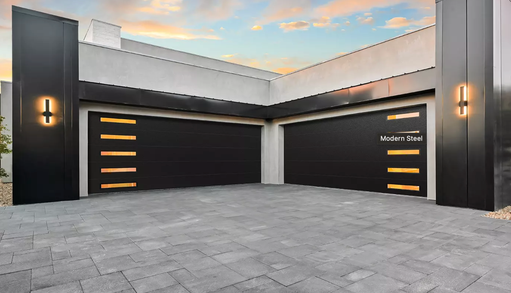 Modern home exterior with black garage doors, gold accents, and a paved driveway.