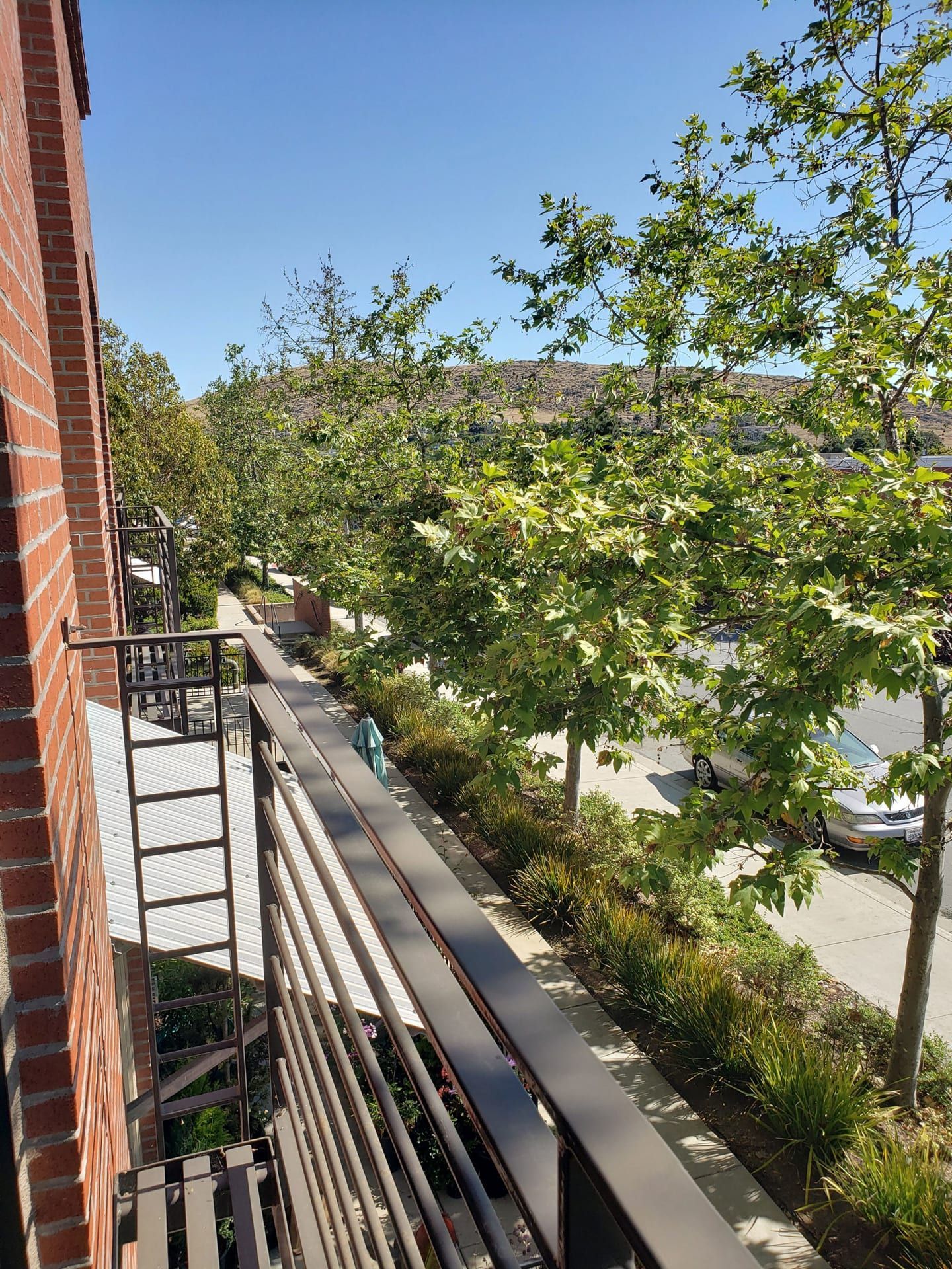A row of apartment buildings with cars parked in front of them