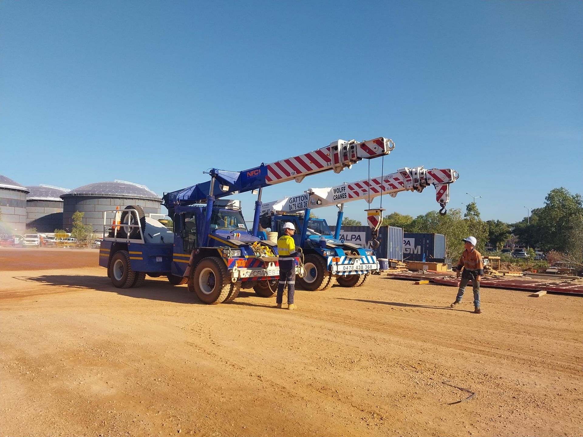 Two Men Standing In Front Of Two Cranes Parked On The Dirt Road — Northern Franna Cranes NT in Noonamah, NT