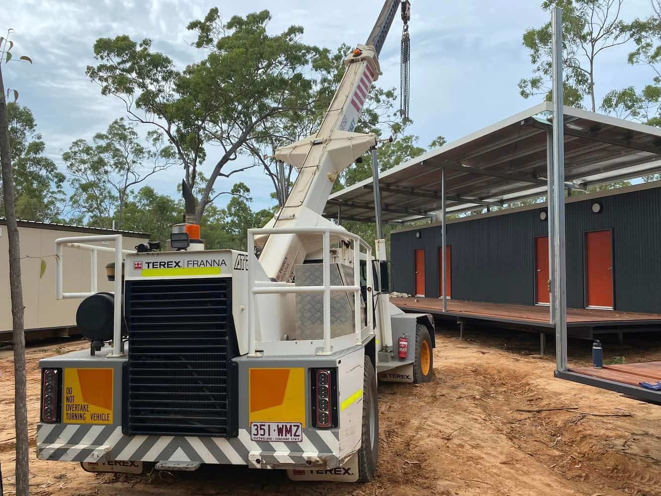 A Truck with A Crane Attached to It Is Parked in Front of A Building Under Construction