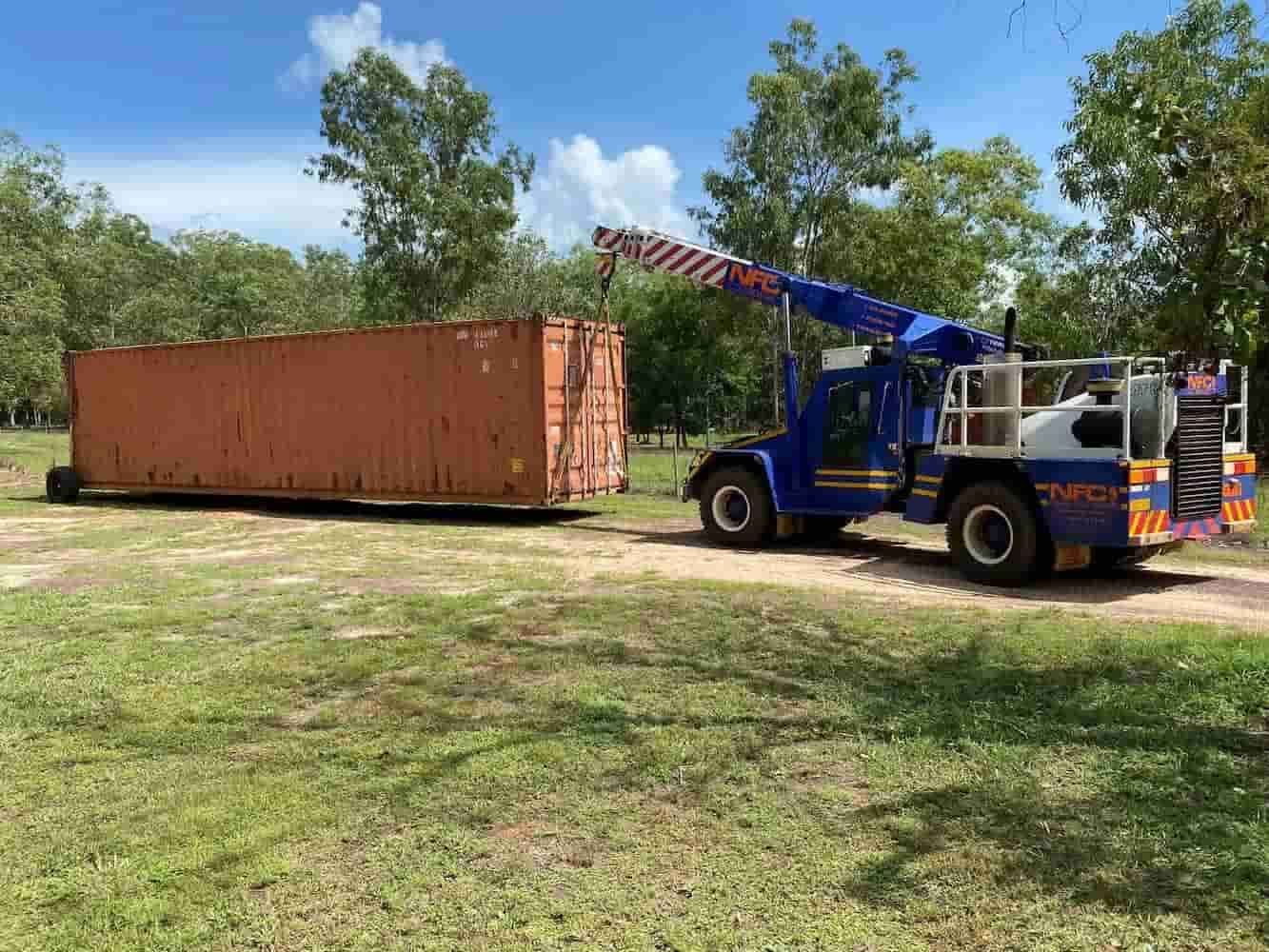 A Blue Tow Truck is Towing a Large Orange Shipping Container — Northern Franna Cranes NT in Katherine, NT