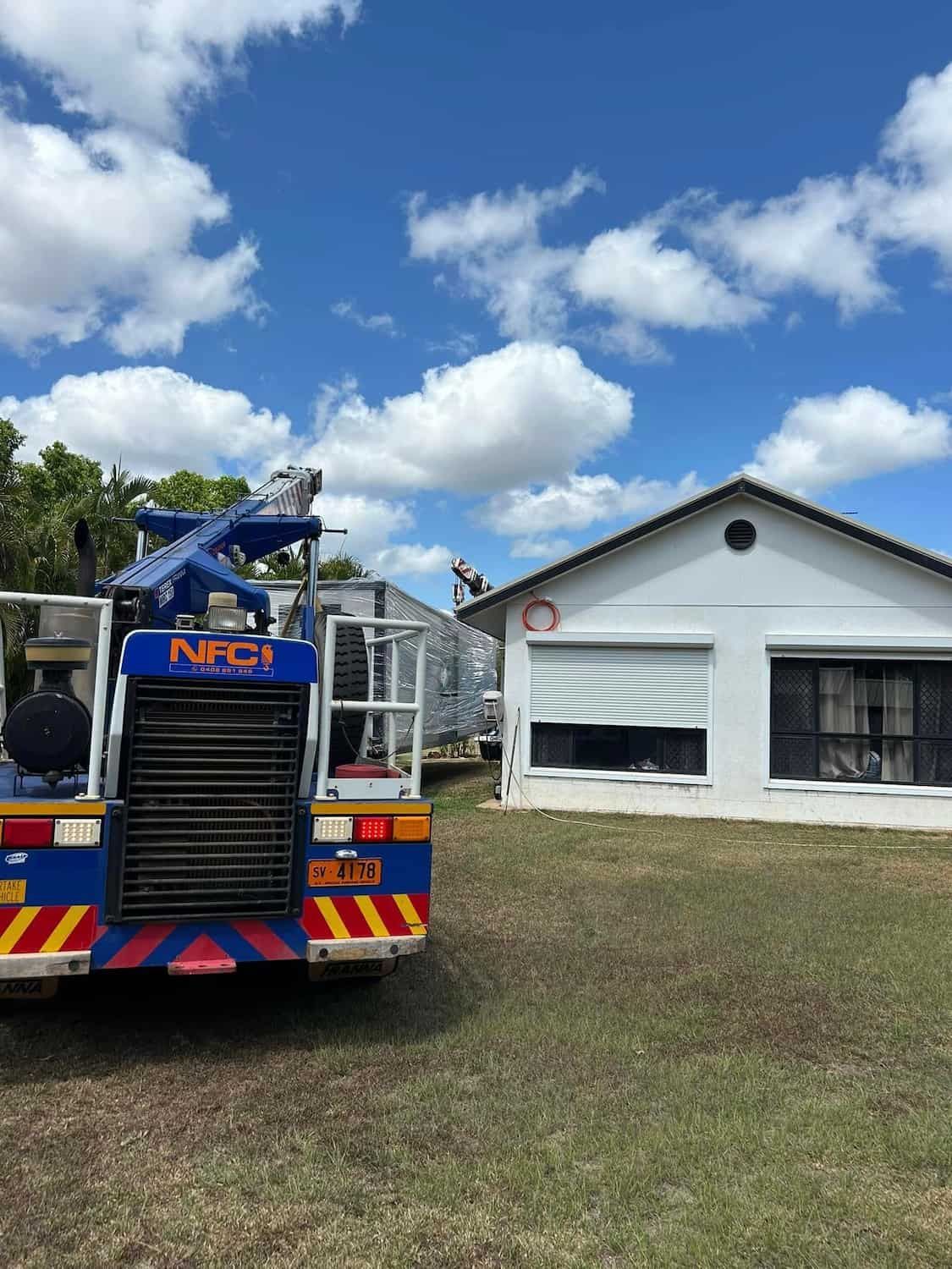 A Blue NFC Truck is Parked in Front of a White House — Northern Franna Cranes NT in Borroloola, NT