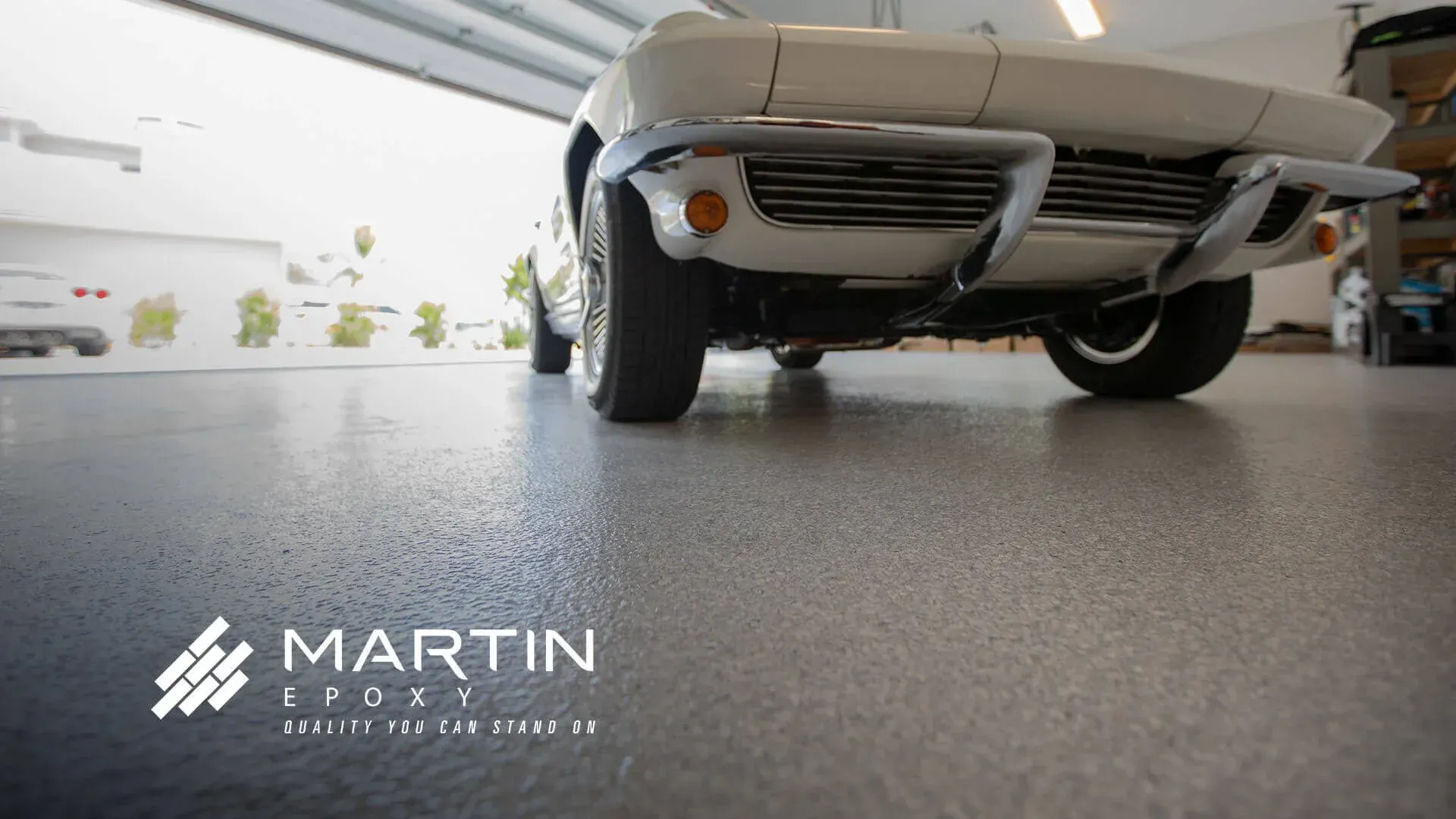 White classic car parked in a garage with a speckled gray epoxy floor. White classic car parked in a garage with a speckled gray epoxy floor.