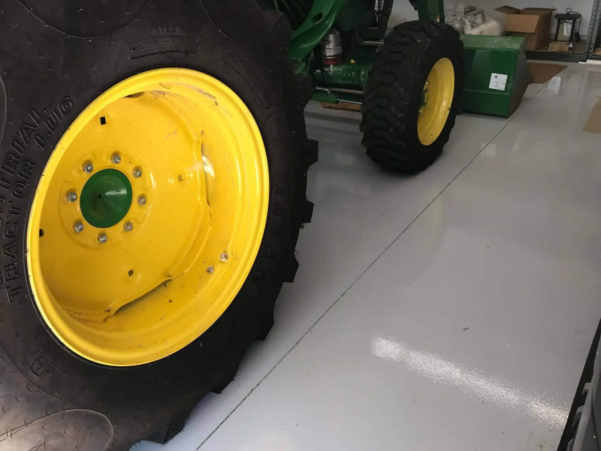 Yellow and green tractor wheels on a light-colored floor. Yellow and green tractor wheels on a light-colored floor.