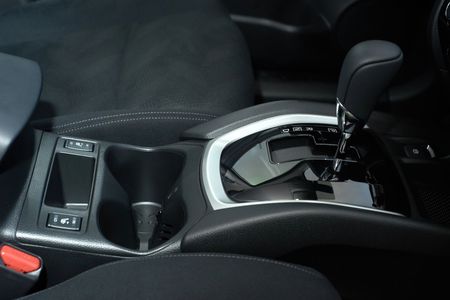 Interni dell'auto che mostrano la console centrale, i portabicchieri e la leva del cambio automatico.