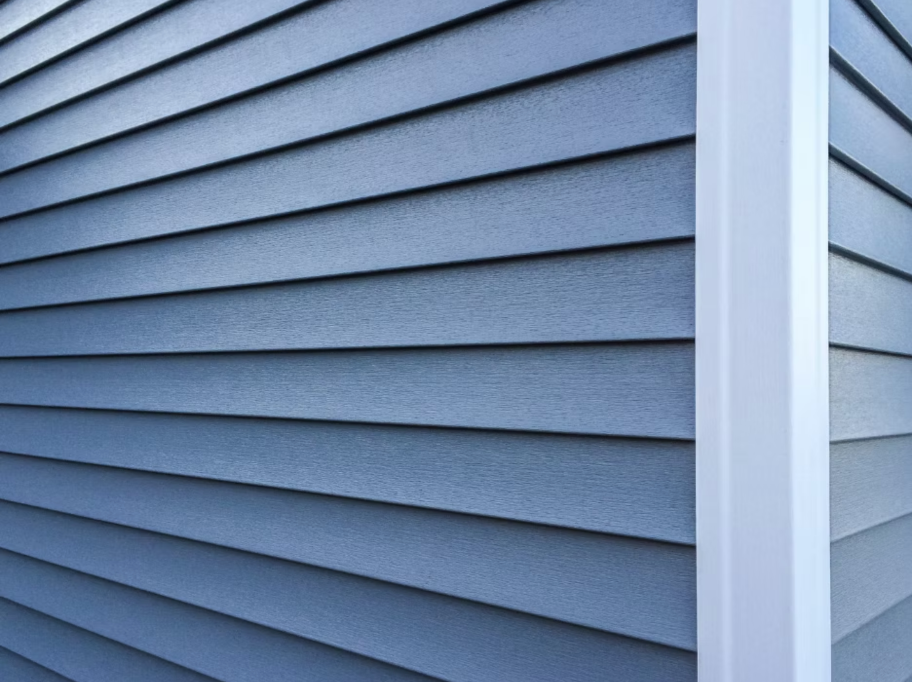 A close up of a blue siding on a house with a white trim