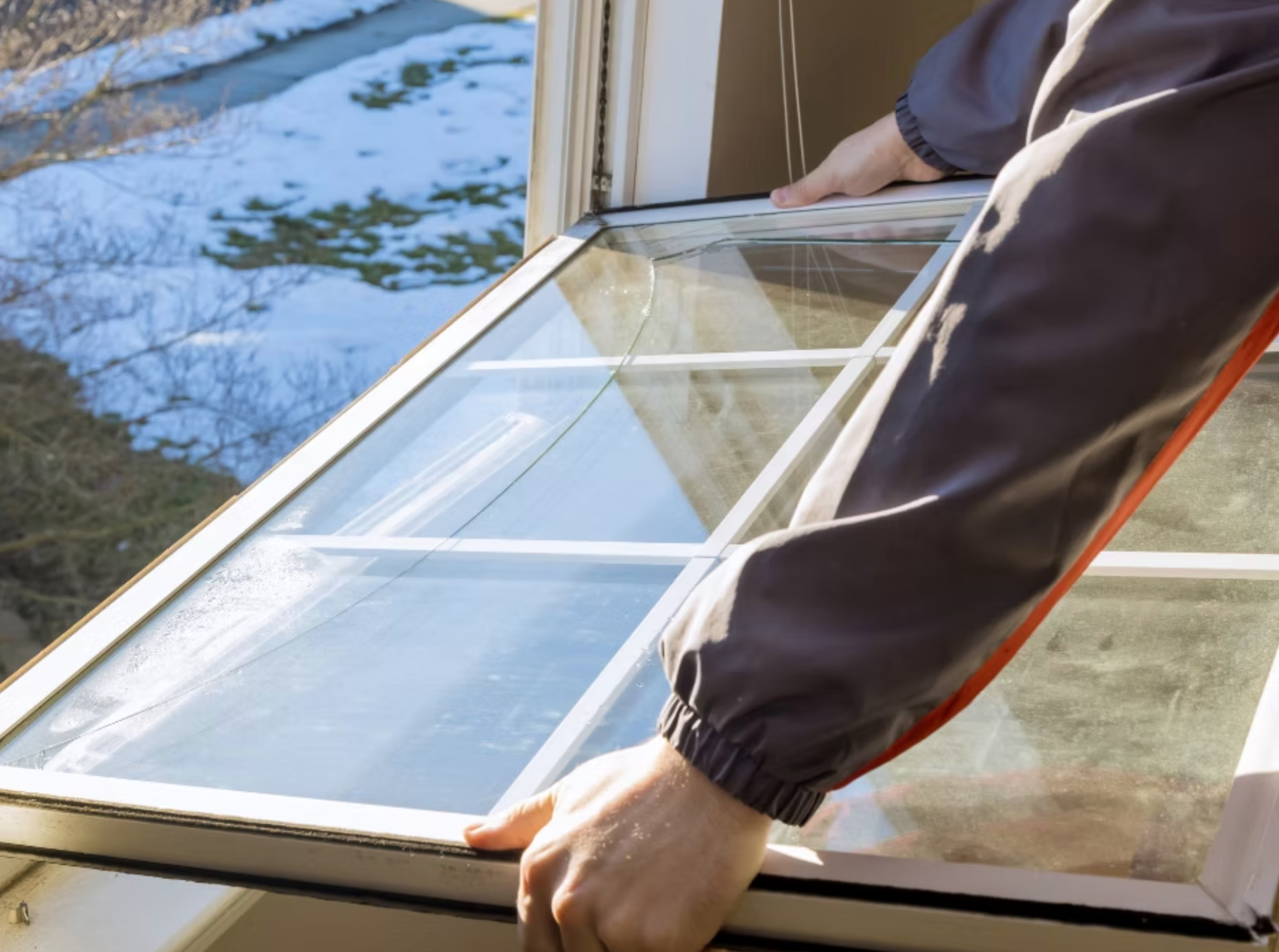 A person is installing a new window in a house.