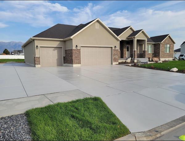 Suburban house with beige siding, three garages, and a wide concrete driveway beside a green lawn