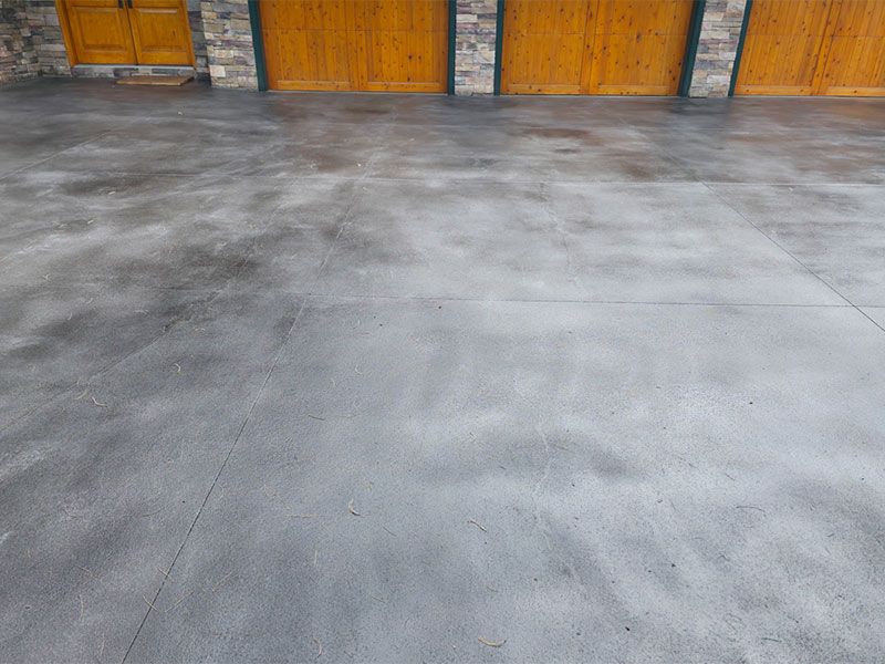 Concrete floor in front of orange wooden garage doors