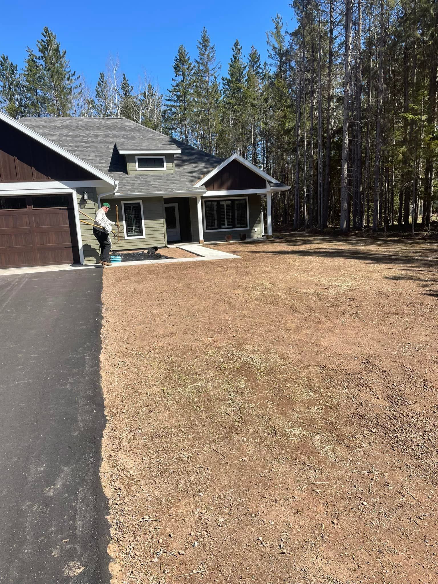 A house with a lot of dirt in front of it and trees in the background.
