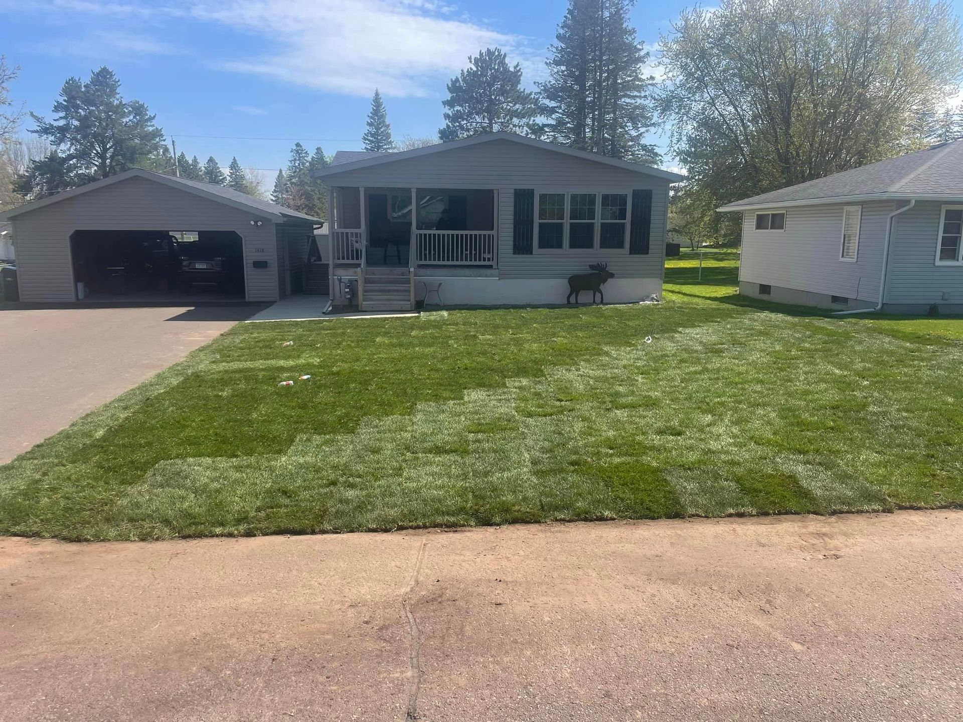 A mobile home with a large lawn in front of it.