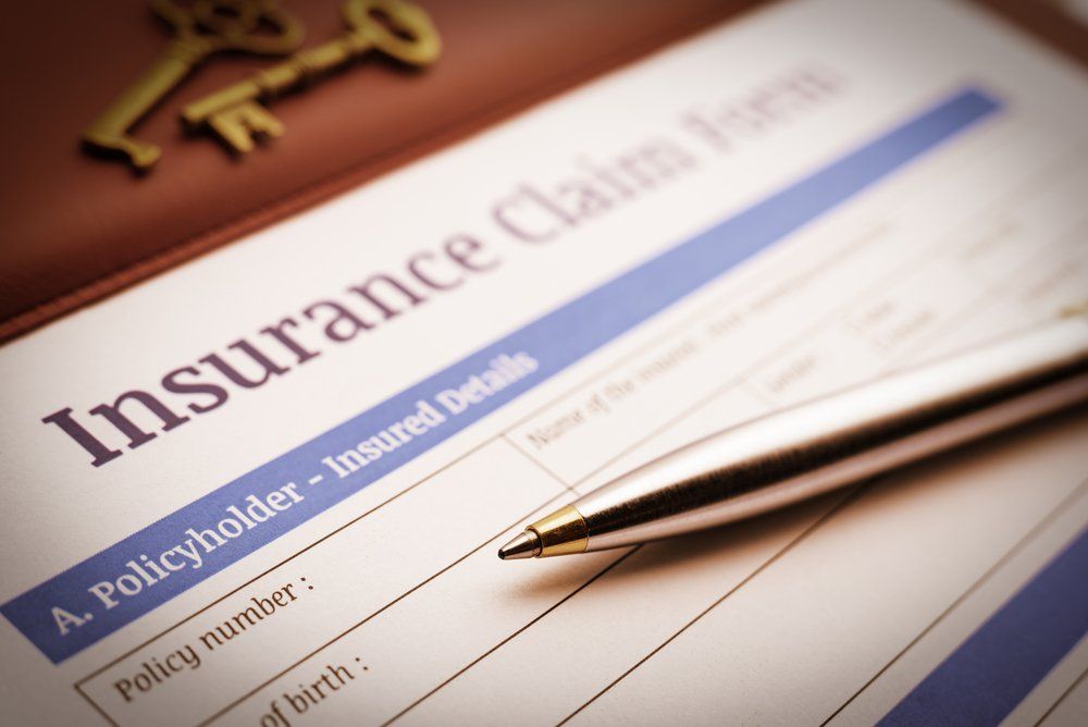 A pen sits on top of an insurance claim form