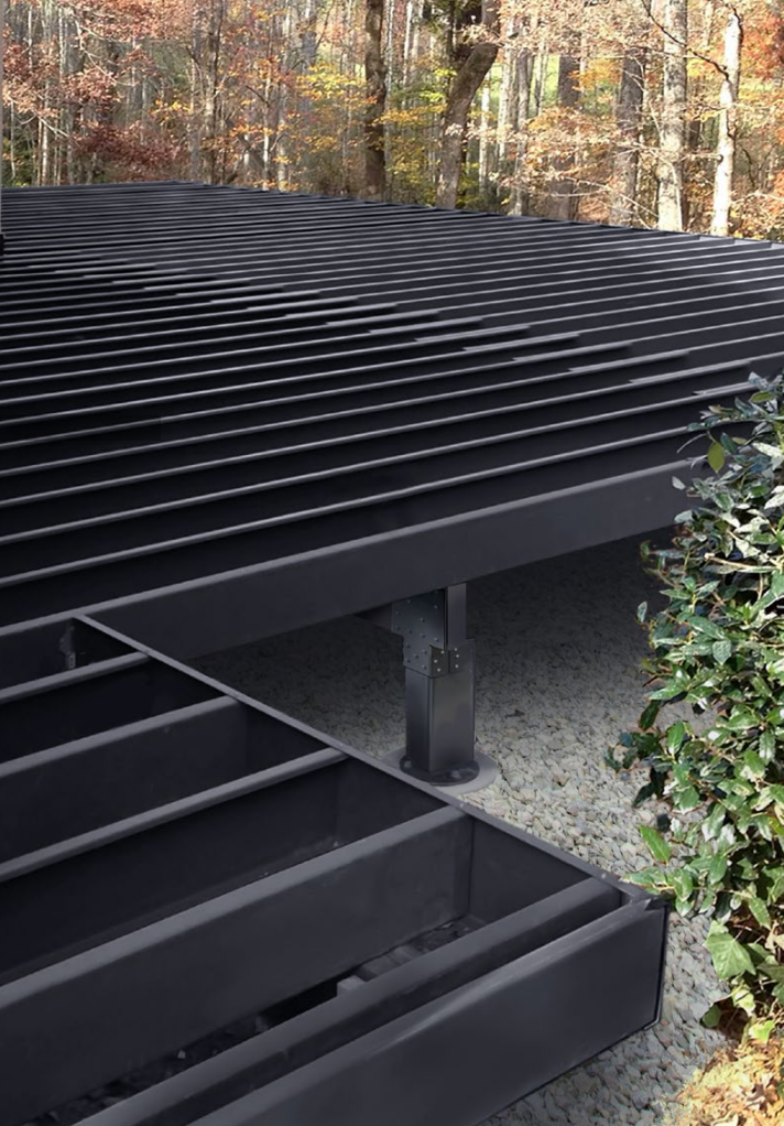 Black slatted deck in a wooded area with beams.