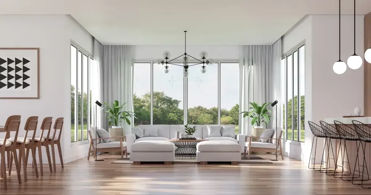 Bright modern living room with white sofas, large windows, wood floors, and a dining table at left Bright modern living room with white sofas, large windows, wood floors, and a dining table at left
