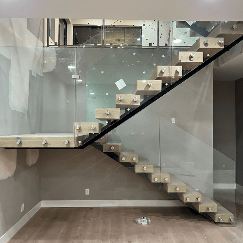 Modern glass staircase with floating wooden steps in a minimalist interior