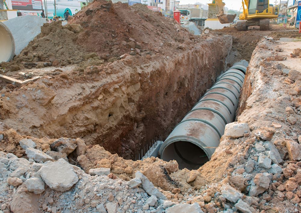 A Large Concrete Pipe Is Being Installed In A Trench — Macquarie Valley Rock & Sand In Narromine, NSW