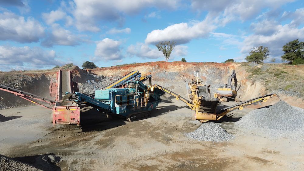 A Group Of Construction Vehicles Are Parked In A Dirt Field — Macquarie Valley Rock & Sand In Dubbo, NSW