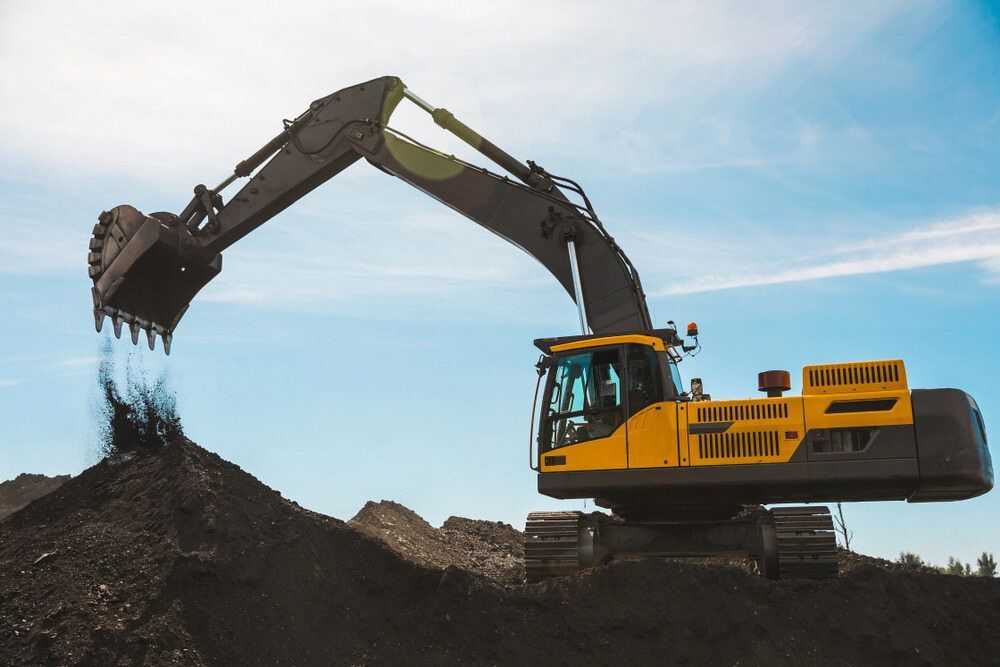 A Large Yellow Excavator Is Digging A Hole In A Pile Of Dirt — Macquarie Valley Rock & Sand In Trangie, NSW