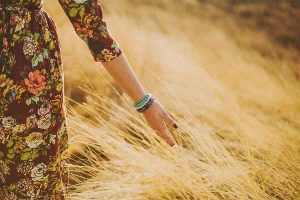 a woman walking through a wheat field