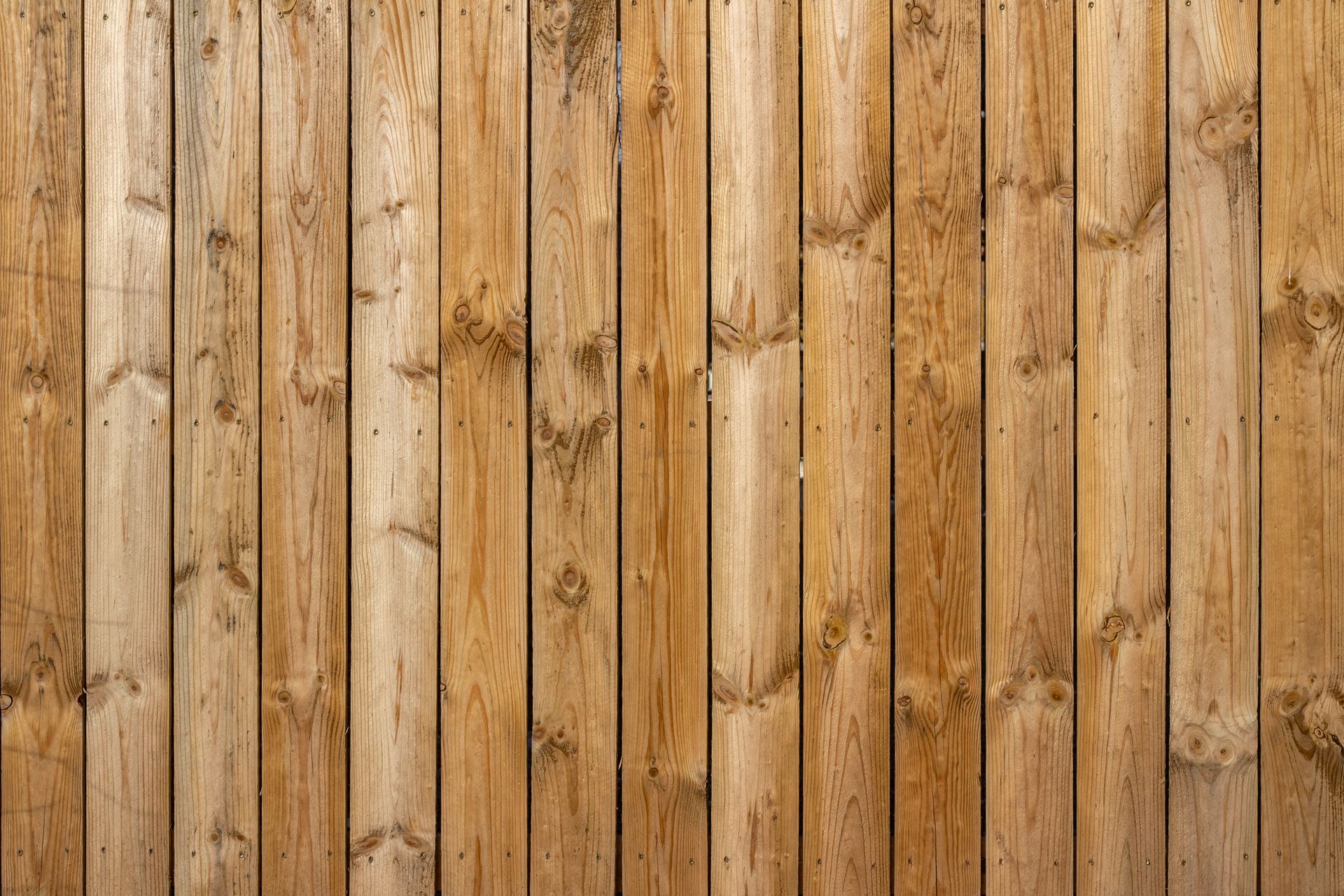 Vertical wooden plank wall with warm brown tones and visible knots and grain