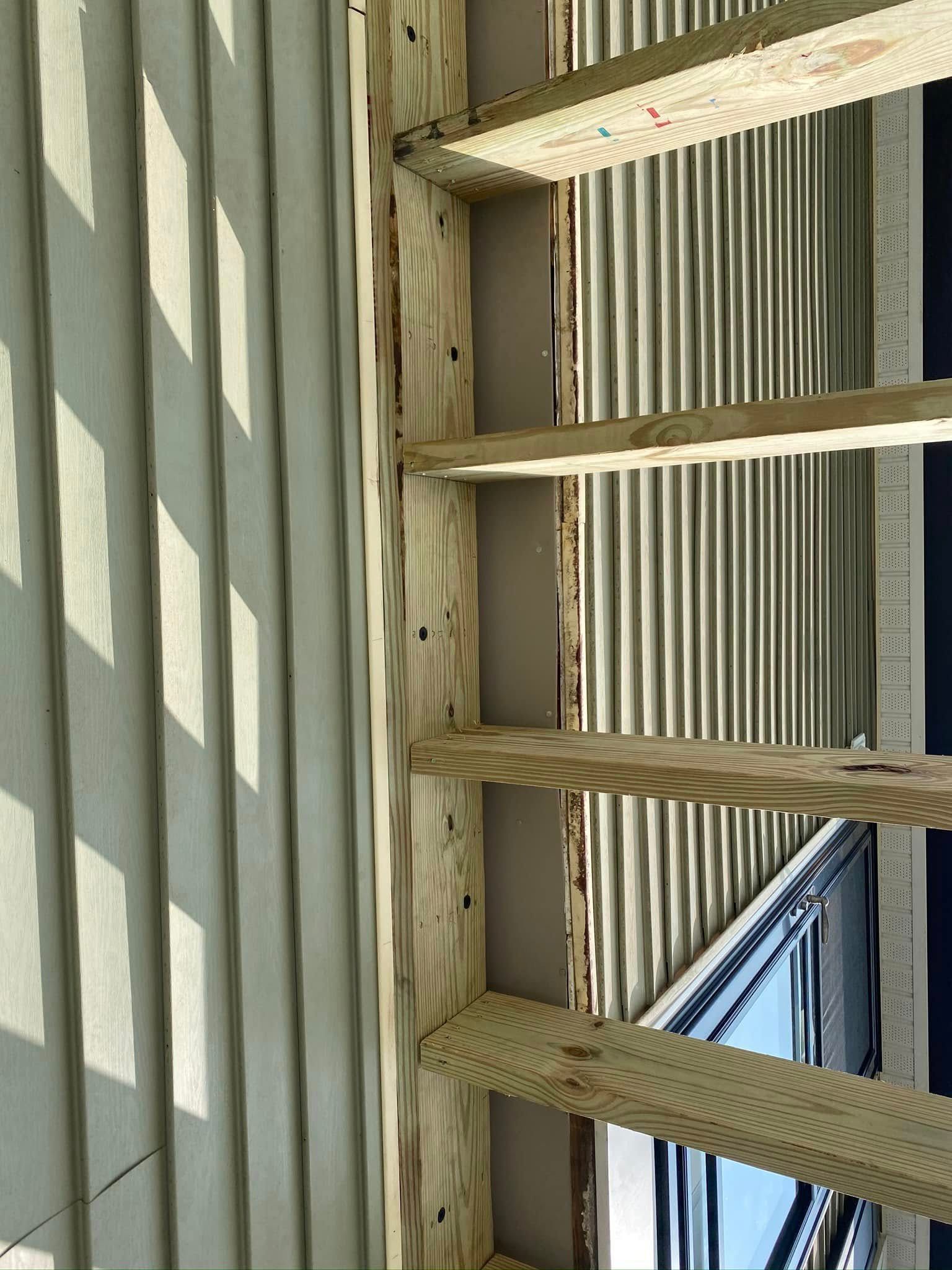 A close up of a wooden structure with a window in the background.