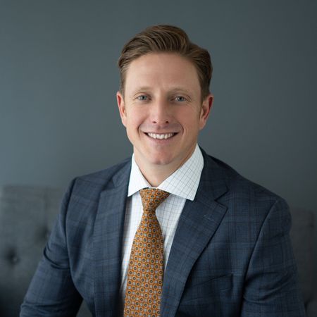 A man in a suit and tie is smiling for the camera.