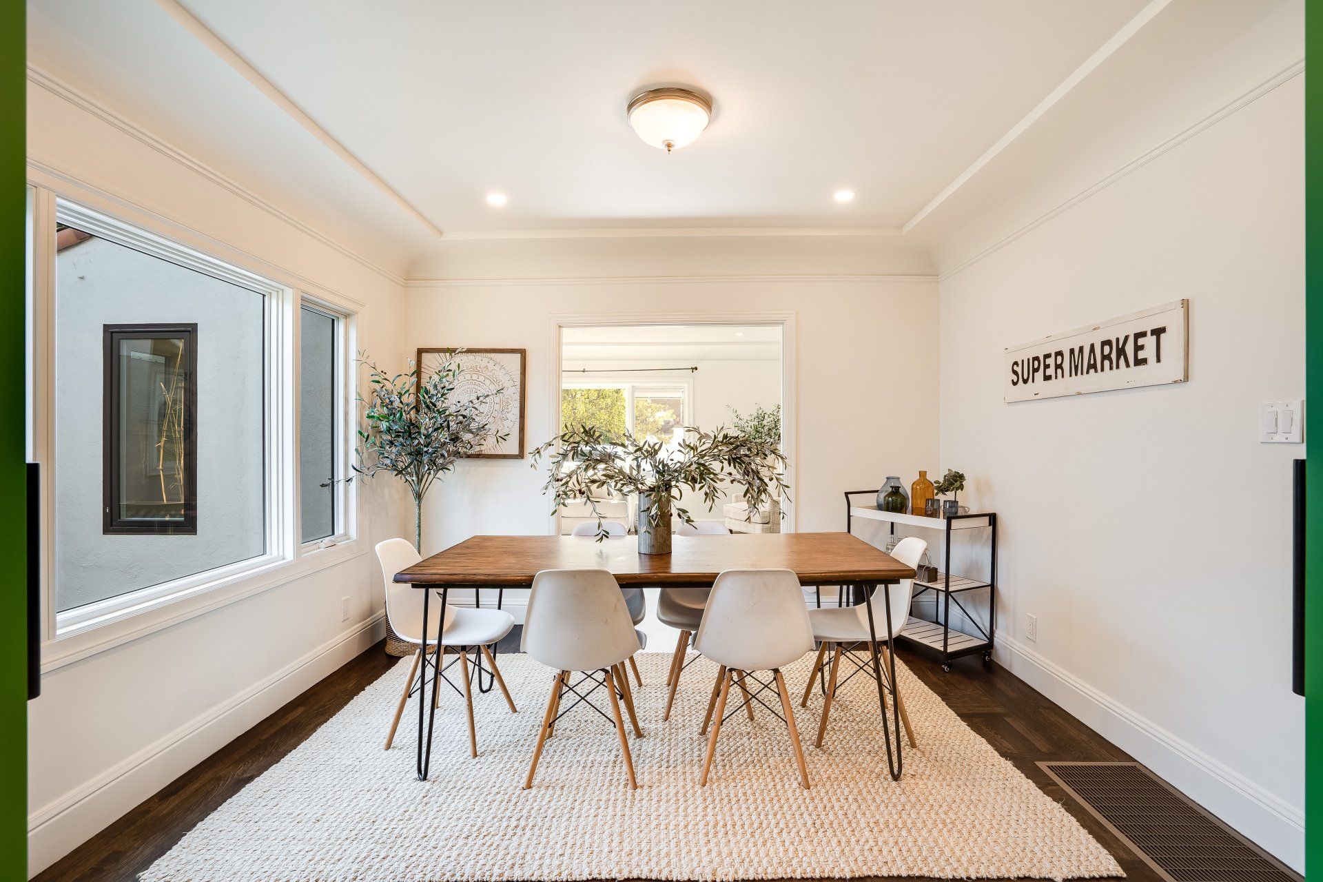 A dining room with a table and chairs and a sign on the wall that says supermarket.