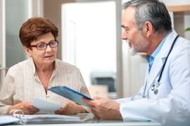 Doctor discussing paperwork with a patient in a clinic office