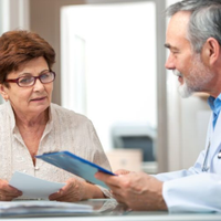 Doctor discussing documents with a woman in a bright office