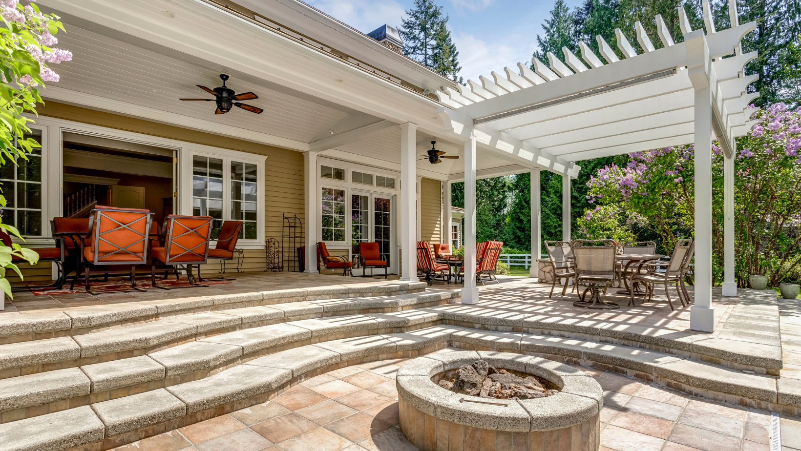 a patio with a fire pit and a ceiling fan