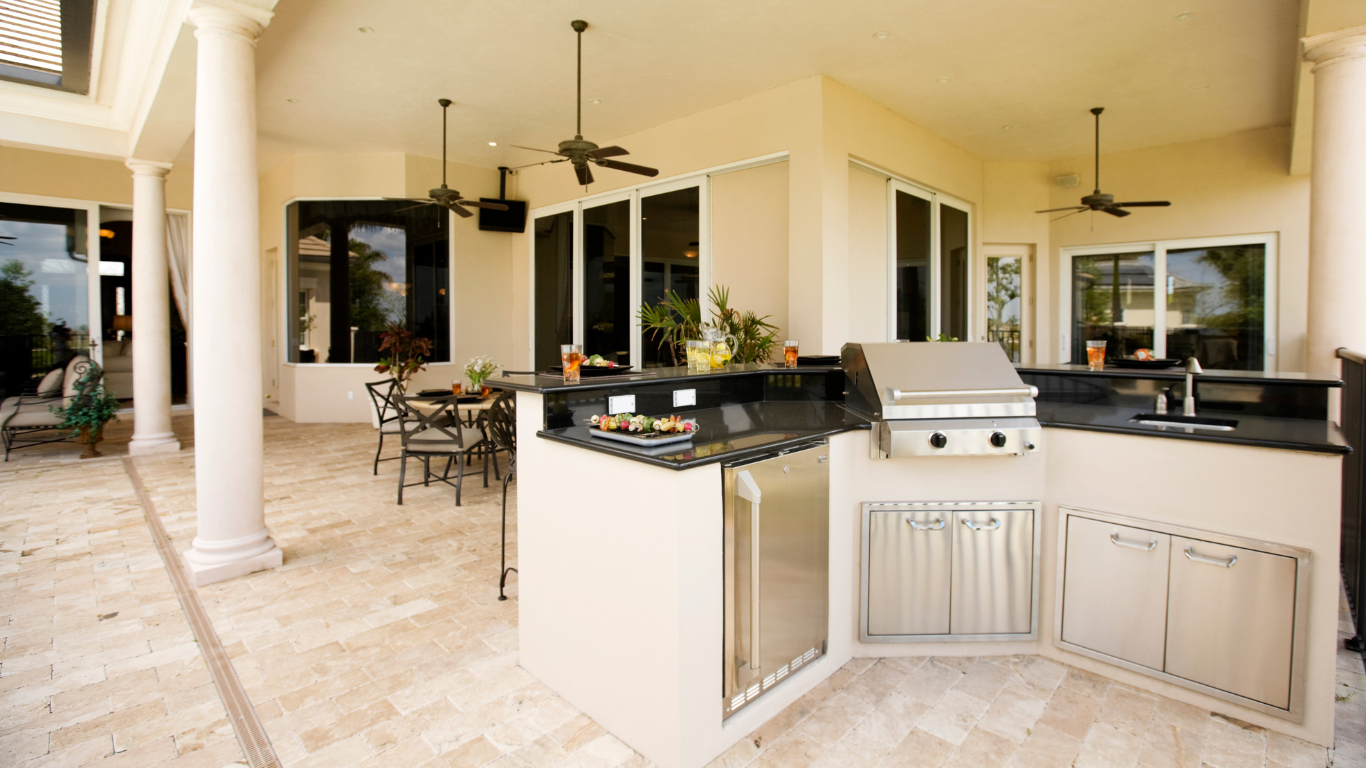 a kitchen with a grill and a stainless steel refrigerator