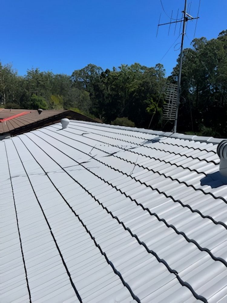 White Metal Roof With Vents, Antenna, and Blue Sky — Cornall Painting Services in Wauchope, NSW