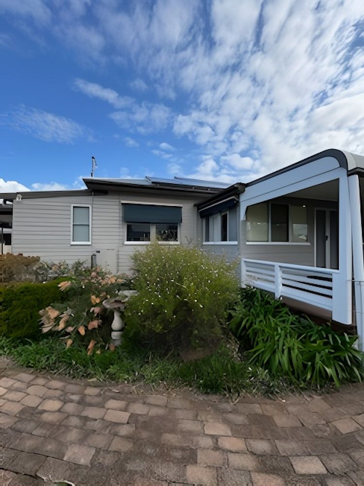 A House With a Porch and a Brick Driveway — Cornall Painting Services in Laurieton, NSW