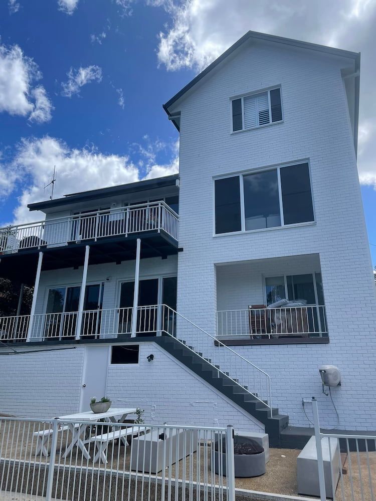 White-painted House With Balcony and Stairs — Cornall Painting Services in Wauchope, NSW 
