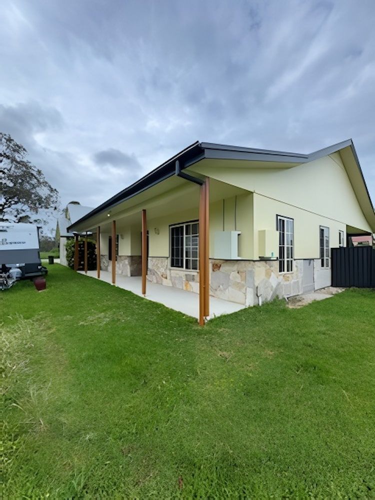 A Large House With a Large Lawn in Front of It — Cornall Painting Services in Lake Cathie, NSW