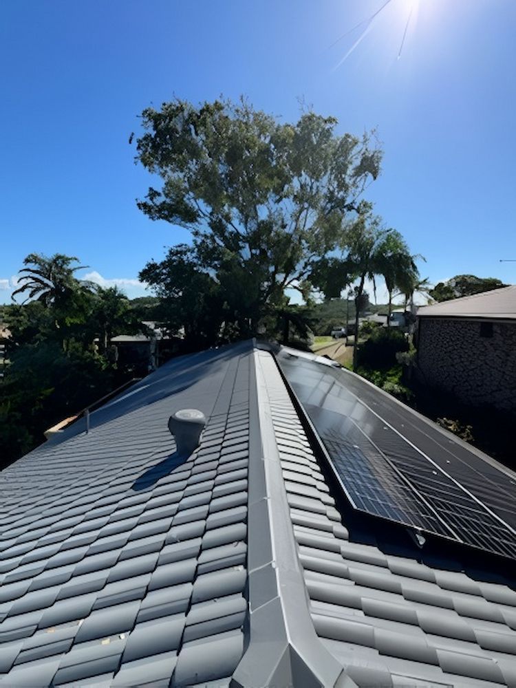 House Roof With Solar Panels Under Clear Blue Sky — Cornall Painting Services in Wauchope, NSW