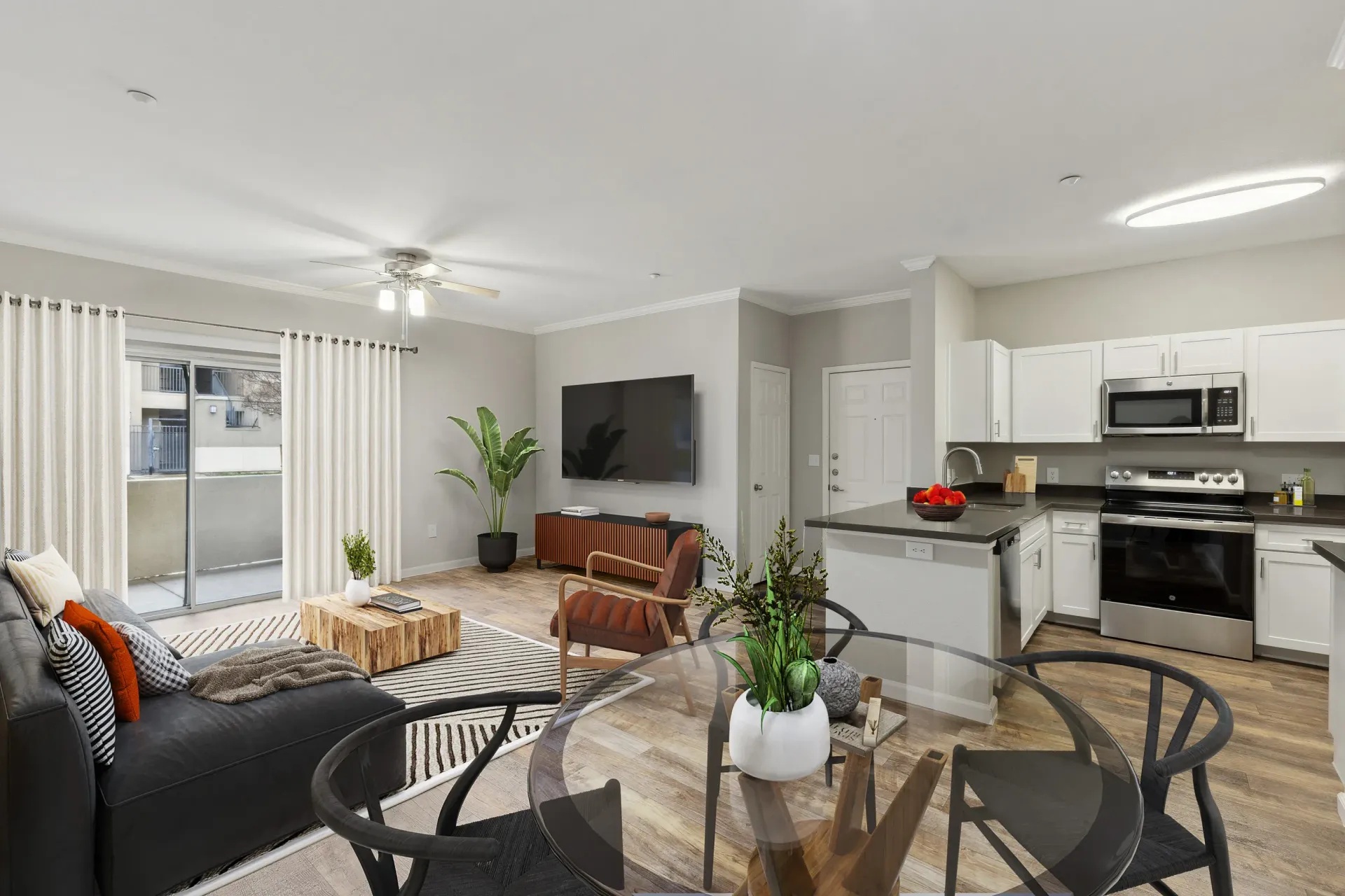 Open-concept living area with sofa, TV, dining table, and adjoining kitchen at Cross Pointe apartments in Antioch, CA.