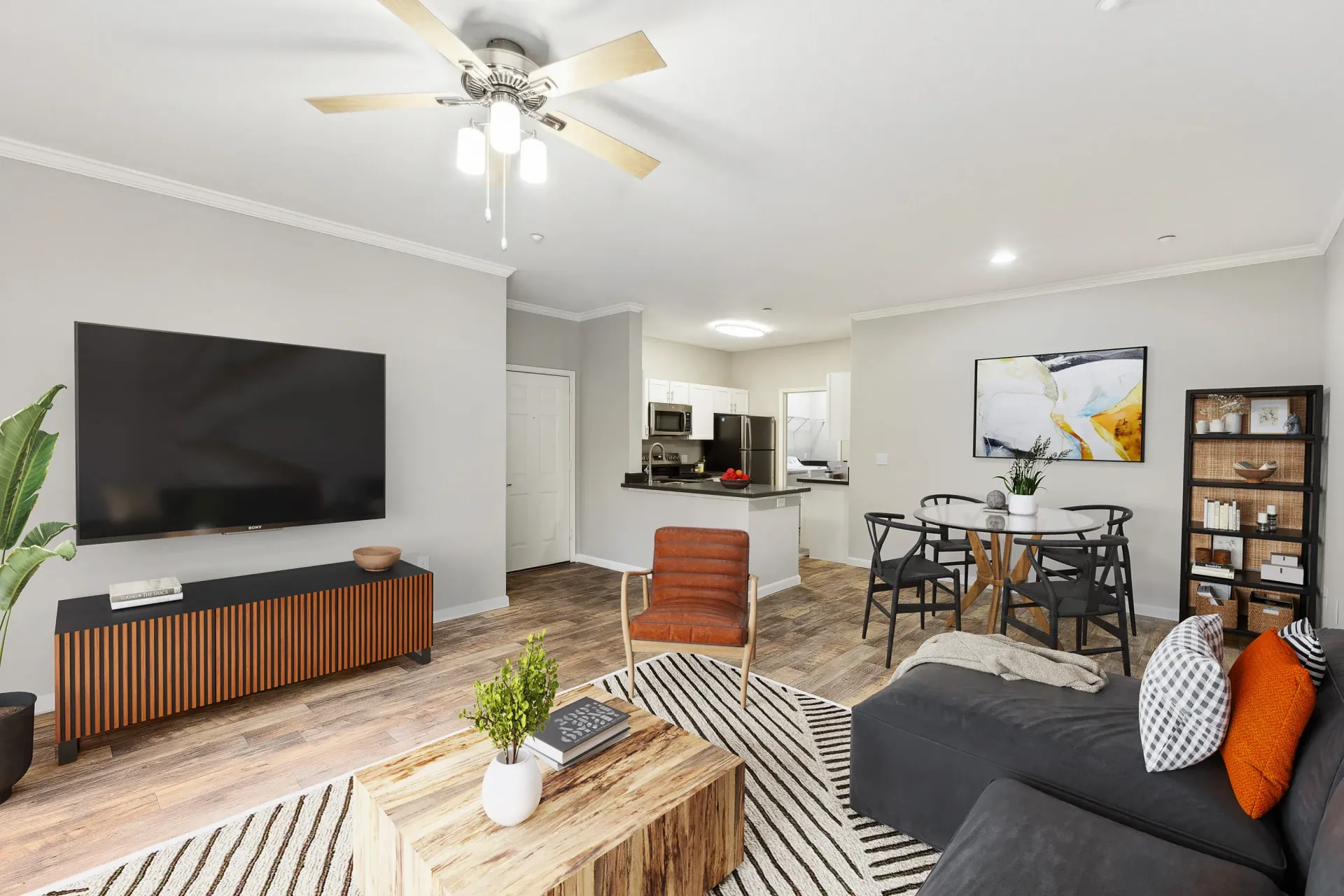 Open-concept living area in a modern apartment with TV, sofa, and dining table at Cross Pointe apartments in Antioch, CA.