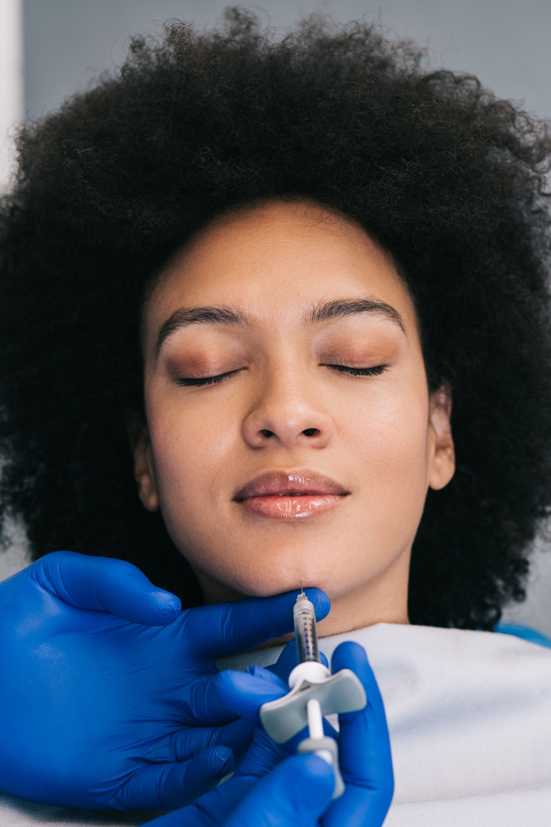 a woman is getting an injection in her face in a beauty salon .