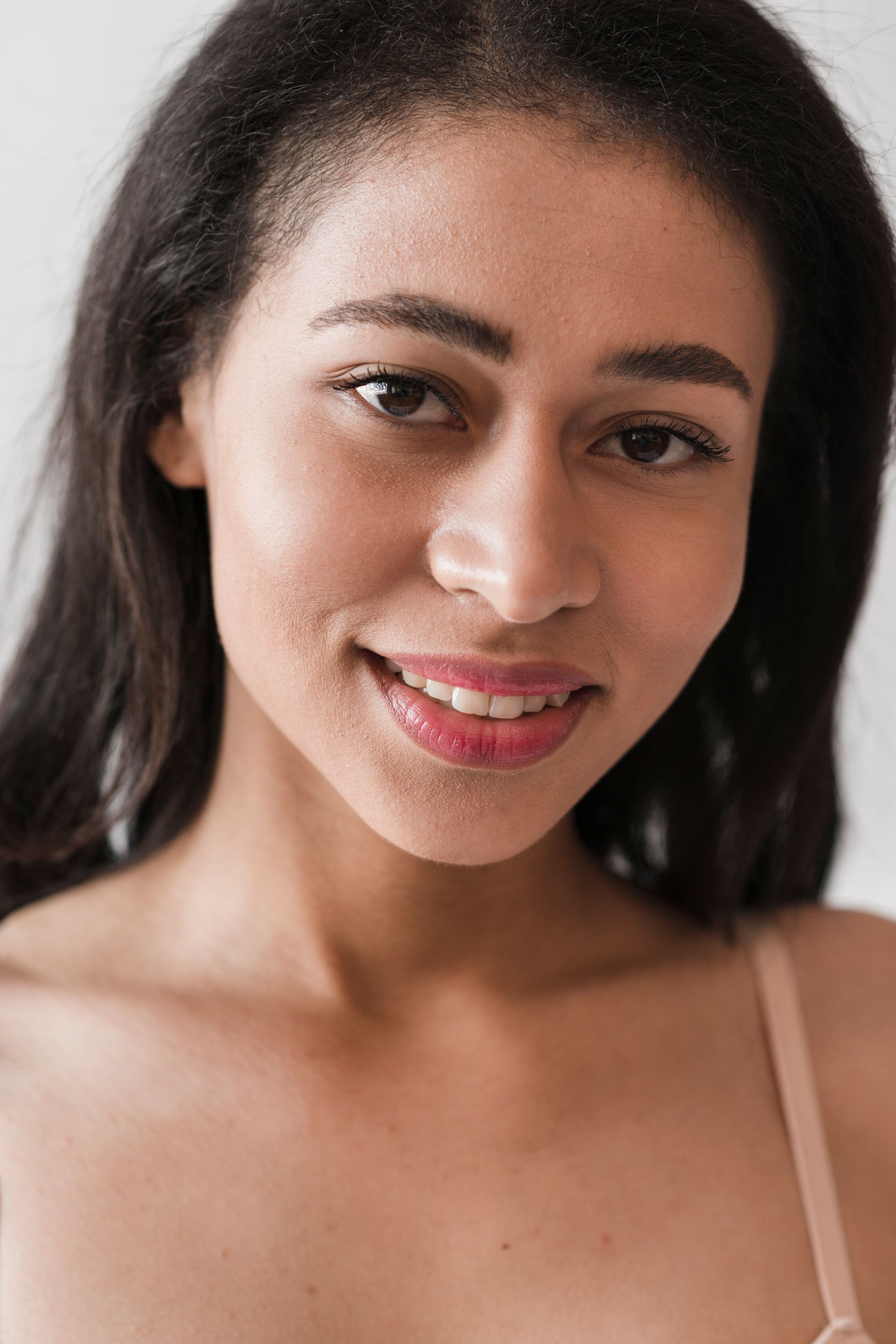 a woman in a bra is smiling and looking at the camera .