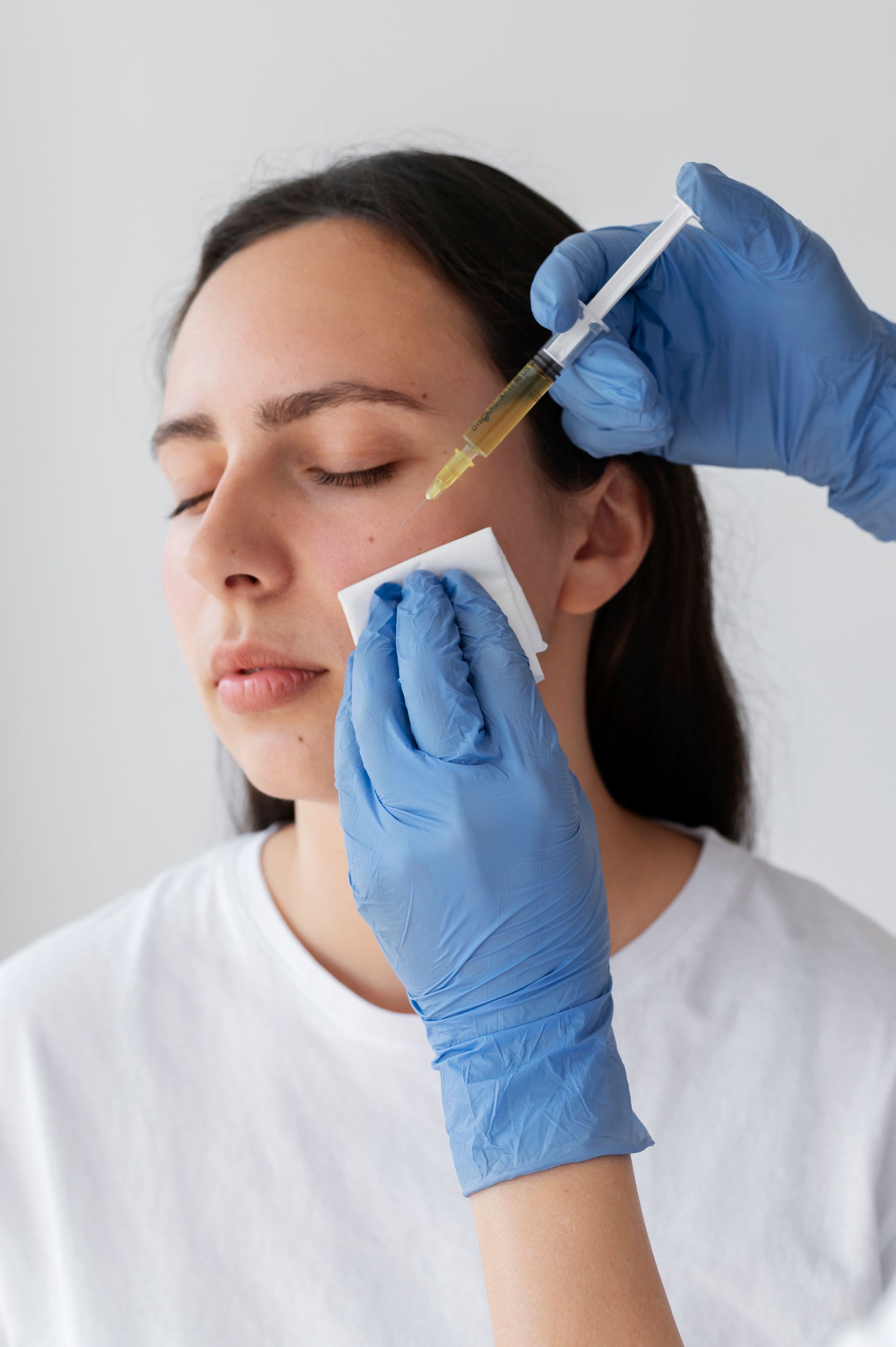 a woman is getting an injection in her face in a beauty salon .