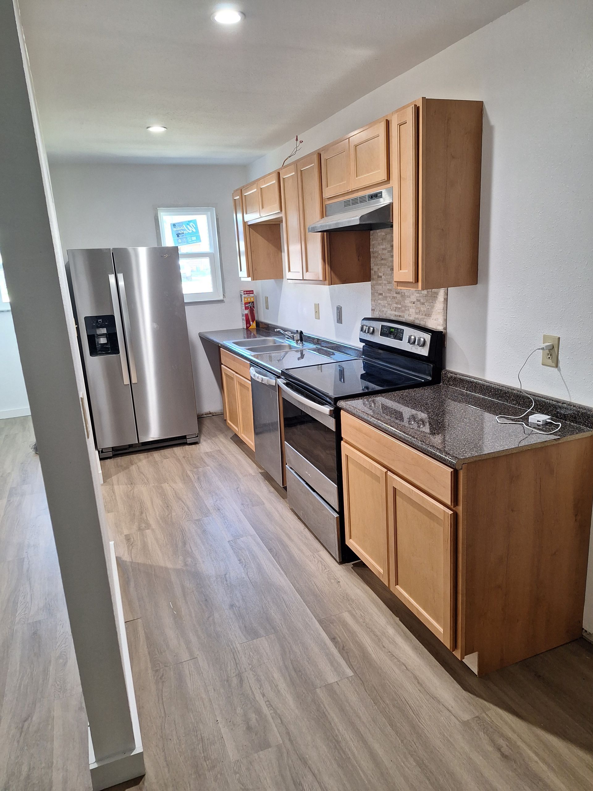 A kitchen with stainless steel appliances and wooden cabinets