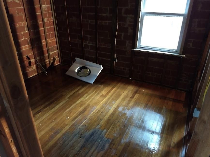 A room with a wooden floor and a window