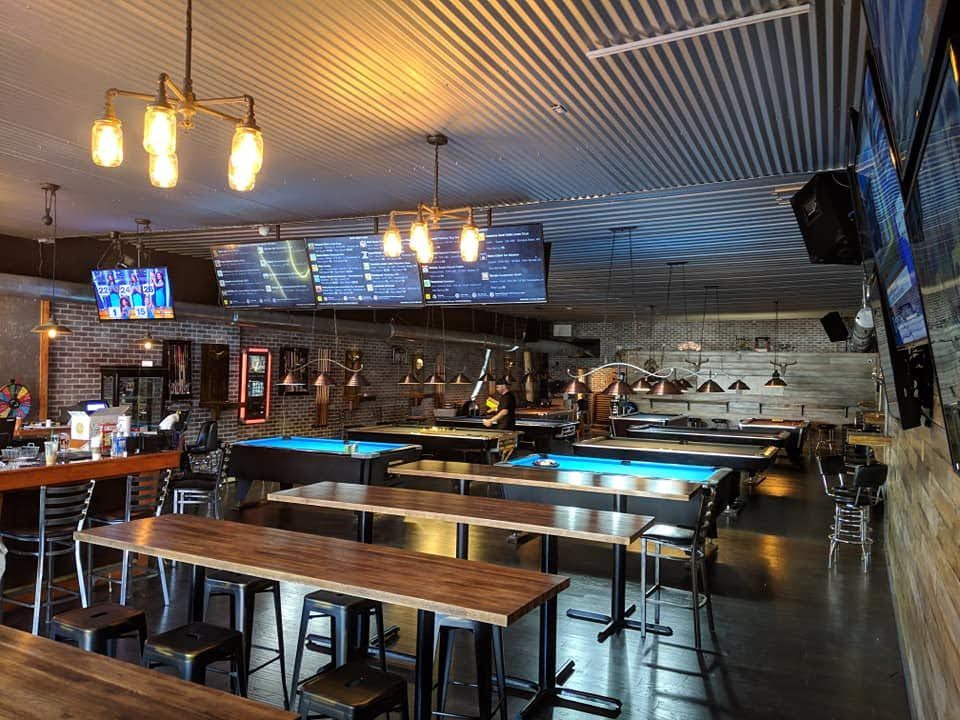 A large room filled with tables and chairs and pool tables.
