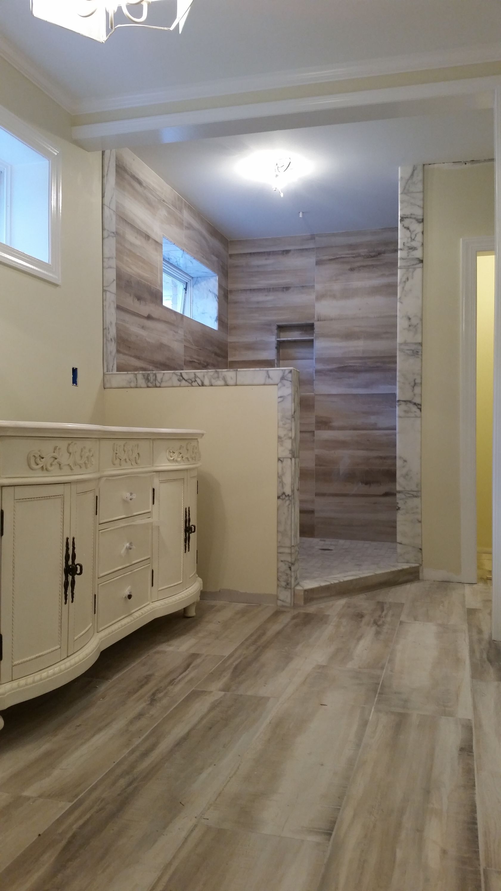 A bathroom with a sink and a walk in shower.