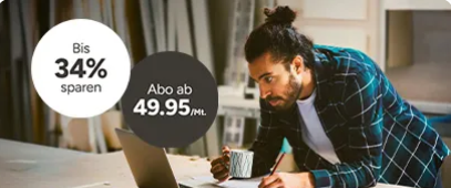 Mann mit Haarknoten arbeitet am Laptop, hält eine Tasse und schreibt. Bietet Ersparnisse von 34 % bei Abonnements ab 49,95 €/Monat.