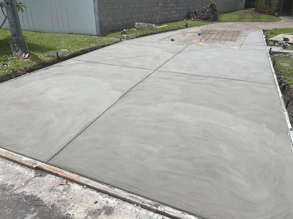 A concrete driveway is being built in front of a house.