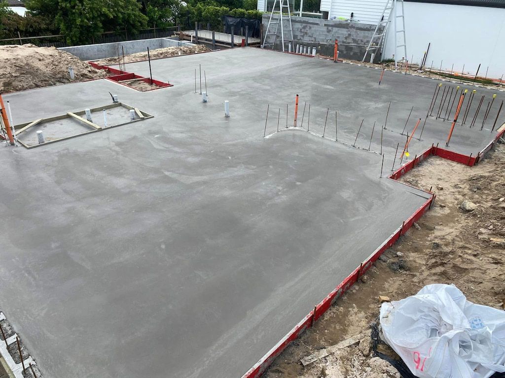 A concrete floor is being built on a construction site.
